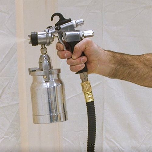 Man Holding HVLP Paint Sprayer Gun